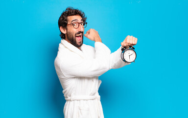 Wall Mural - young bearded man wearing bathrobe and an alarm clock