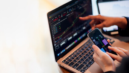 Two business investor trading or stock brokers having a planning and analyzing with display screen and pointing on the data presented and deal on a stock exchange.