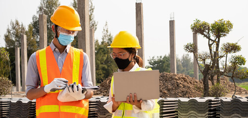 A team of male and female engineers or architects is exploring and inspecting the outdoor construction site work