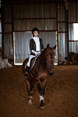 Young woman is engaged in equestrian sports, training on horseback