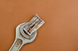 © Mikhail - Old metal wrench and bill on a brown background.