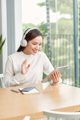 Fototapete - Freelance business woman using tablet working call video conference with customer in workplace in living room at home.