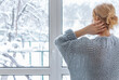 © Дворецкая Таня - A woman looks out of the window at the snow-covered outdoors