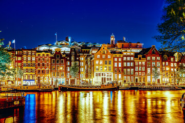 Famous Amstel river and night view of beautiful Amsterdam city. Netherlands