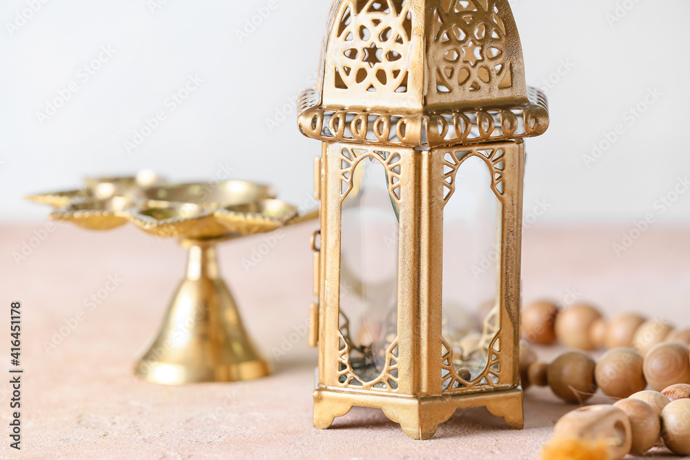 Muslim lamp and tasbih on light background