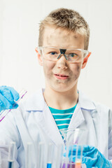 Wall Mural - funny boy dressed as chemist with dirty face after a failed experiment