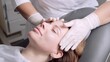 © markwar - Doctor in white medical gloves doing relaxing facial massage to young woman. Professional cosmetologist or beautician doing facial massage in the beauty salon to his patient.