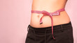 © Инесса Бологова - bow of centimeter ribbon on the waist of a woman, the concept of weight loss, healthy lifestyle.