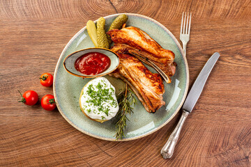 Wall Mural - Fried pork ribs, pickles, potatoes and sauce on a blue plate