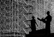 Two workers black silhouette over huge scaffolding background
