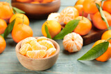 Fototapeta Na sufit - Fresh tangerine slices on blue wooden table