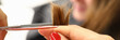 © H_Ko - Hairdresser hold strand of hair in her hand and cut part of it with scissors to visitor close-up in beauty salon.
