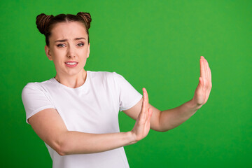 Wall Mural - Portrait of pretty worried girl showing stop sign disgust dislike isolated over vibrant green color background