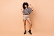 © deagreez - Full length body size photo of woman relaxing on weekend in printed shirt isolated on pastel beige color background