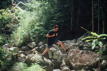 Male tourist on the stones in the rainforest.