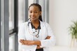 © Serhii - Portrait of female African American doctor standing in her office at clinic