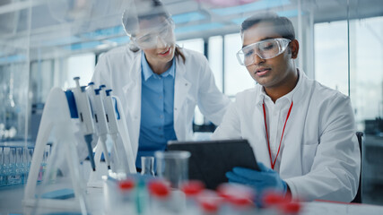 Wall Mural - modern medical research laboratory: two scientists working together analysing samples, discussing in