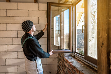 Wall Mural - a professional worker inserts a new window