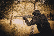 © Dmitry Dven - A soldier in special black equipment. Warrior without insignia and stripes. Special forces in the woods aiming with weapons. Tactical exercises.
