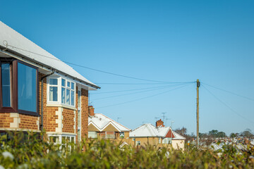 Wall Mural - Houses roofs covered with winter snow in england uk