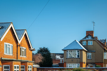 Wall Mural - Houses roofs covered with winter snow in england uk