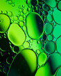 Oil drop bubbles on a water surface abstract with a green  stripe background