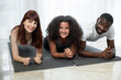 © sofiko14 - Smiling parents, African American father and Caucasian mother, doing plank with their cute teen mixed race daughter