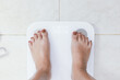 © Charlie's - feet standing on electronic scales for weight control. Measurement instrument in kilogram for a diet control.