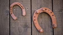 Old Rusty Horseshoe On The Rustic Wooden Wall Background.