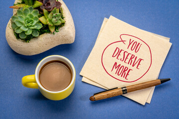 Wall Mural - you deserve more motivational note - handwriting on a napkin with a cup of coffee, business, education and personal development concept