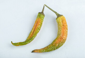 Top view of two dried green hot peppers on white background