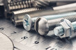 © evkaz - set of different nuts, bolts, screws, washers and drill bits,thread tap and mill cutters on steel plate background. Locksmithing deal.