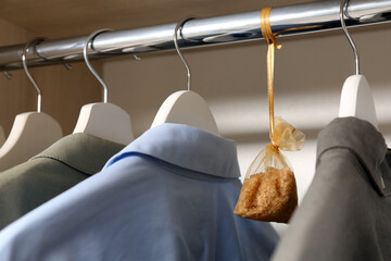 Scented sachet and clothes hanging in wardrobe