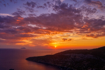 Aerial drone shot sunset over Adriatic horizon from Komiza town port on Vis Island in Croatia summer