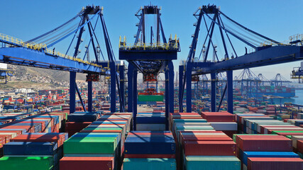 Aerial closeup photo of colourful container seaside port and logistics terminal in crane area while loading-unloading to container tanker vessel