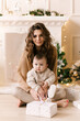 © ksyusha_yanovich - happy family mother and child daughter on Christmas morning at the Christmas tree with gifts