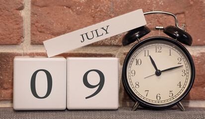 Wall Mural - Important date, July 9, summer season. Calendar made of wood on a background of a brick wall. Retro alarm clock as a time management concept.