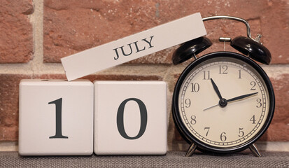 Wall Mural - Important date, July 10, summer season. Calendar made of wood on a background of a brick wall. Retro alarm clock as a time management concept.