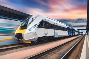Wall Mural - high speed train in motion on the railway station at sunset. modern intercity passenger train with m