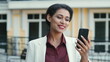 © stockbusters - Smiling mixed race woman video chatting outside. Lady looking phone screen