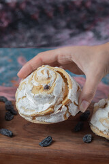 Fried meringue cookie with black raisines and white chocolate on the top