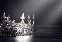 Silver Metal King Or Queens Crown On A Black Wood Table