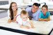 © JackF - Little funny boy with brother and parents testing mattress in store