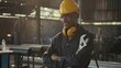 © sorapop - Portrait American industrial black young worker man smiling with yellow helmet in front machine, Engineer standing holding wrench tools and arms crossed at work in the industry factory.