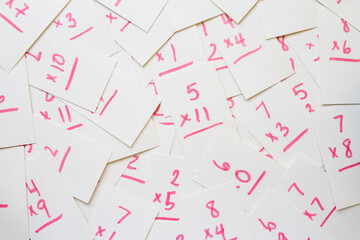 Multiplication flash cards spilled onto a pile; scattered math flash cards background