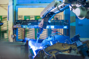 Wall Mural - View of robot welding arm in production line of automotive factory.