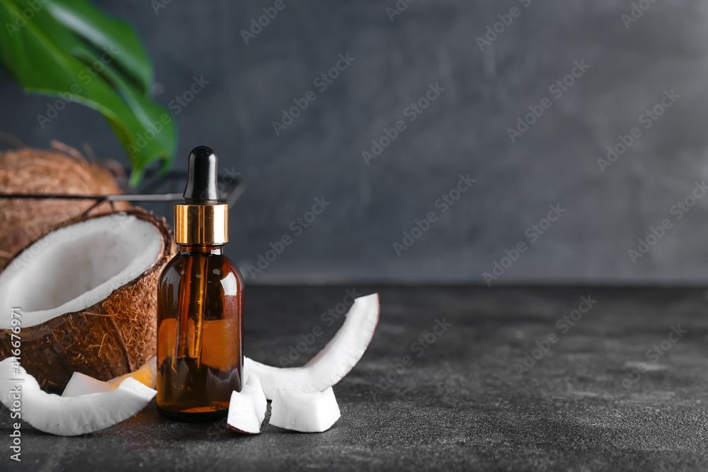 Composition with bottle of coconut oil on dark background