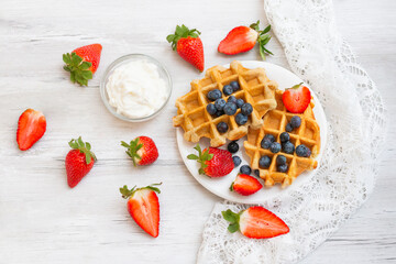 Wall Mural - Homemade belgian waffles with  strawberries and blueberries. Delicious Breakfast with berries.