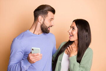 Poster - Profile photo of impressed brunette nice couple hold telephone wear sweater isolated on beige color background