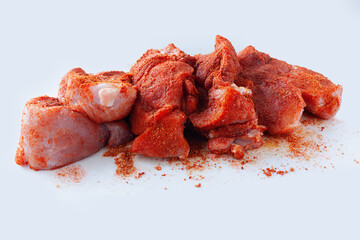 Wall Mural - Pork tenderloin cut in pieces and covered with dry rub spices, ready for grill, on white background